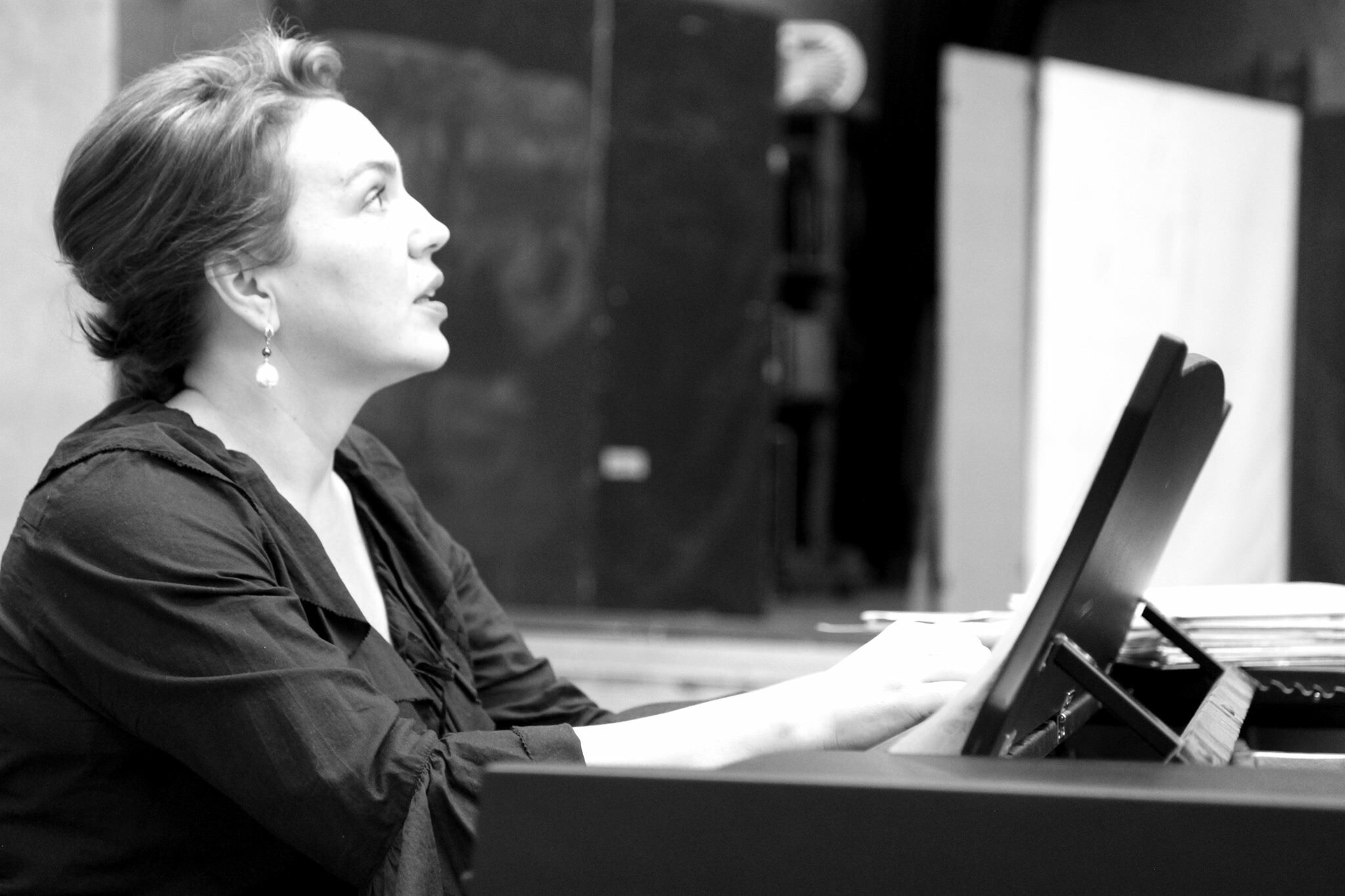 KI generiert: Das Bild zeigt eine Frau, die an einem Klavier sitzt und spielt. Sie scheint konzentriert und vertieft in ihre Musik zu sein.